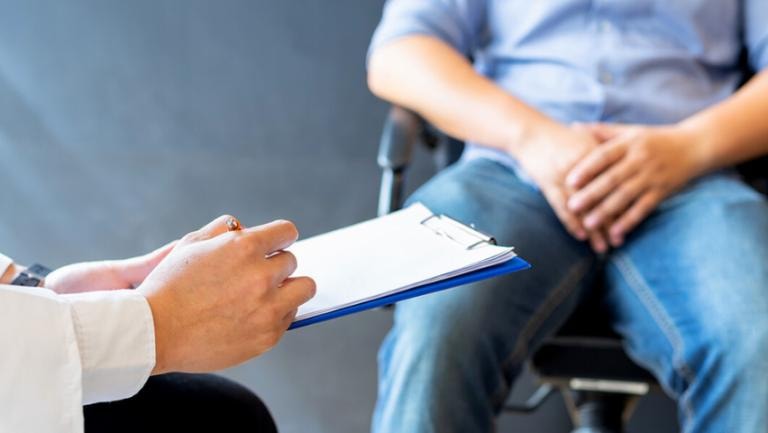 Doctor consulting patient with clipboard