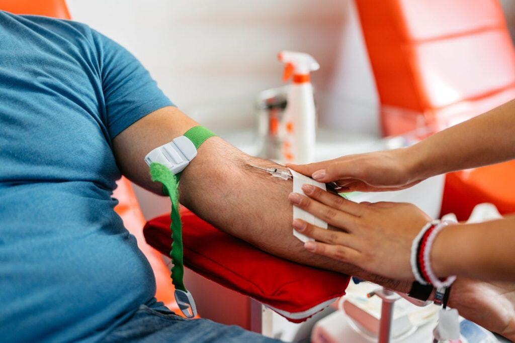 Person applying first aid bandage on arm